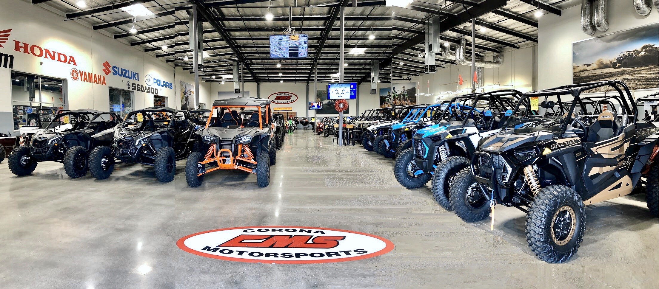 Corona Motorsports Showroom features rows of brightly colored UTVs and motorcycles.
